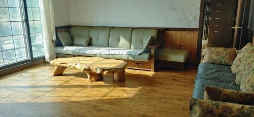 a living room with a couch and a coffee table at Songha Village in Jeongseon