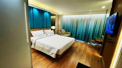 a bedroom with a bed and a tv in a room at Roopa Elite in Mysore
