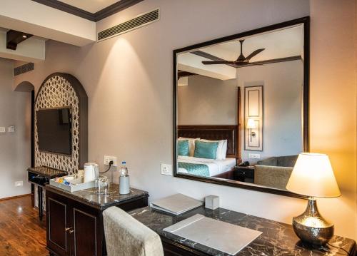 1 dormitorio con cama y tocador con espejo en The Vintage Srinagar at Dal Lake en Srinagar