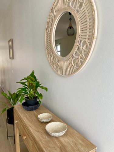 a mirror on a wall above a wooden table with a plant at Villa TE URA Beach in Paea