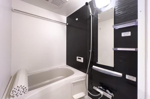a small bathroom with a tub and a sink at toggle BUNKYO KORAKUEN in Tokyo