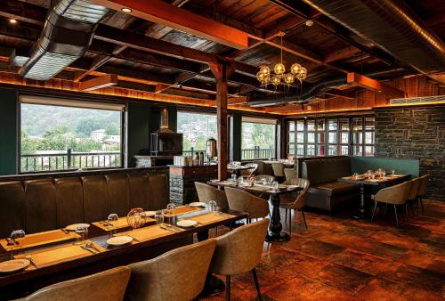 a restaurant with tables and chairs and windows at The Vintage Srinagar at Dal Lake in Srinagar