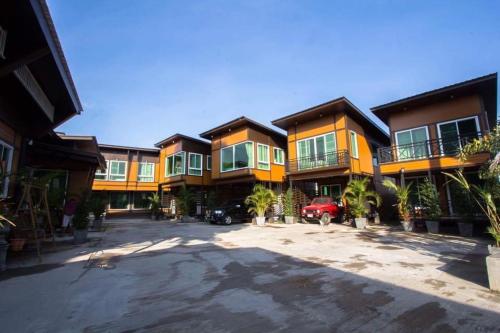 een rij appartementen op een parkeerplaats bij TG Home Residence in Chiang Rai