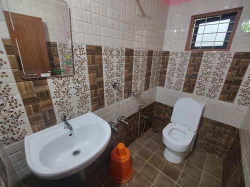 a bathroom with a sink and a toilet at Ventos Tent Stay and Aframes in Anachal