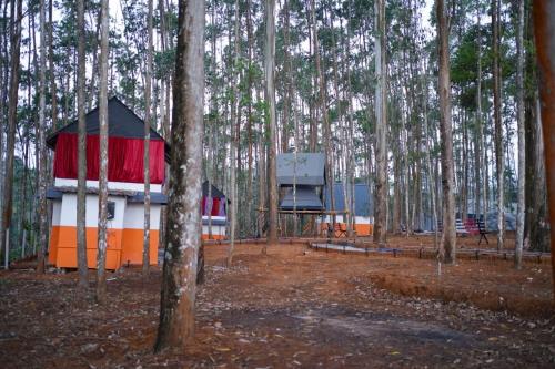 a cabin in the middle of a forest with trees at Ventos Tent Stay and Aframes in Anachal