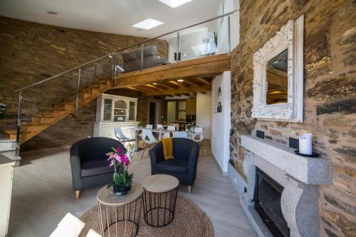 a living room with a fireplace and a stone wall at Casa Juancito in Santiago de Compostela