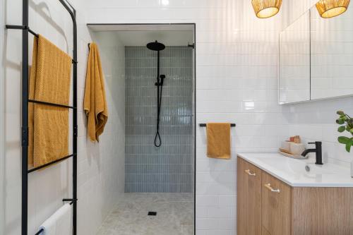 a bathroom with a shower and a sink at Maggies The Little Black Cottage - Hunter Valley in Cessnock