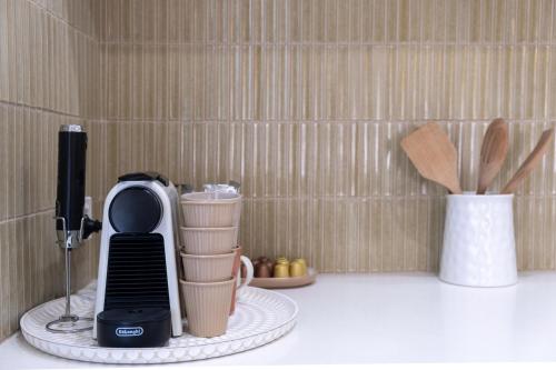 a kitchen counter with a blender and a coffee maker at Maggies The Little Black Cottage - Hunter Valley in Cessnock