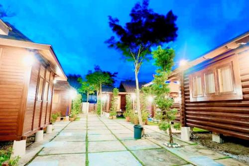 a walkway between two houses at night at 巴厘岛风格住宿 Muar Balinese Resort in Muar