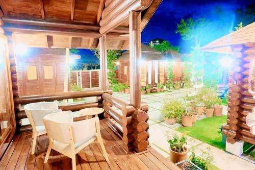 a patio with a table and chairs on a wooden deck at 巴厘岛风格住宿 Muar Balinese Resort in Muar