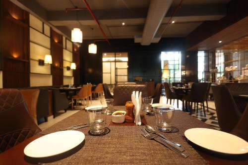a table with plates and napkins on it in a restaurant at Hotel Polo Towers Agartala in Agartala