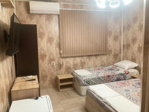 a small room with two beds and a tv at Guesthouse Dune in Sofia