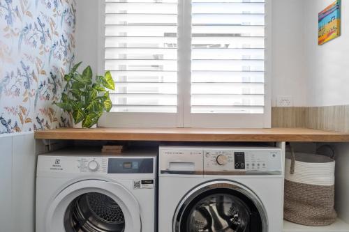 a laundry room with a washer and dryer at Maggies The Little Black Cottage - Hunter Valley in Cessnock