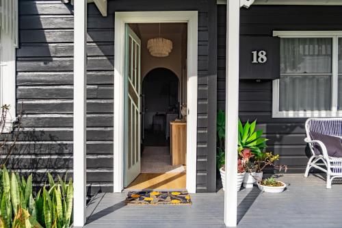 a front door of a house with a black house at Maggies The Little Black Cottage - Hunter Valley in Cessnock