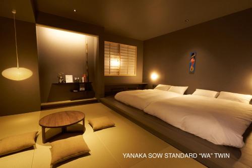 a bedroom with a large white bed and a table at YANAKA SOW - Cultural Boutique Hotel in Historical area Yanaka - Near Ueno Akiba in Tokyo