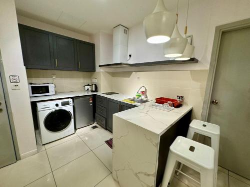 a small kitchen with a stove and a dishwasher at SA Sutera Avenue Homestay Opposite Imago KK in Kota Kinabalu