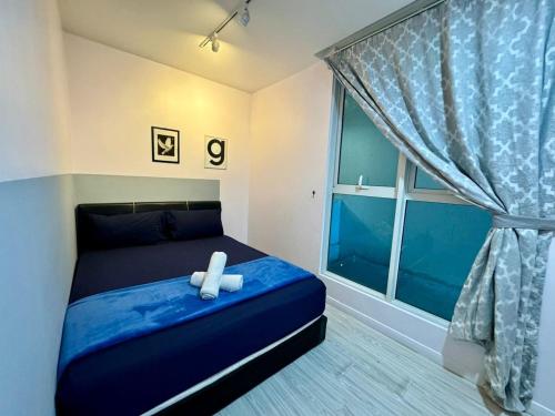 a bedroom with a blue bed with a white cross on it at SA Sutera Avenue Homestay Opposite Imago KK in Kota Kinabalu