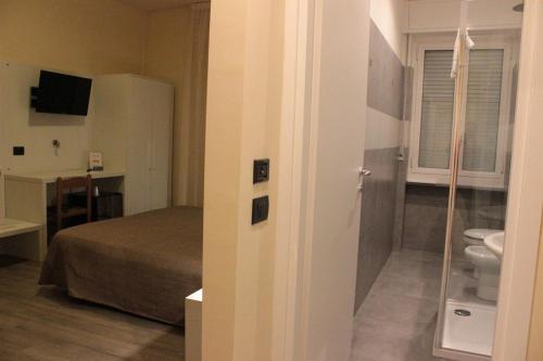 een slaapkamer met een bed en een toilet in een kamer bij Hotel Rex Milano in Milaan