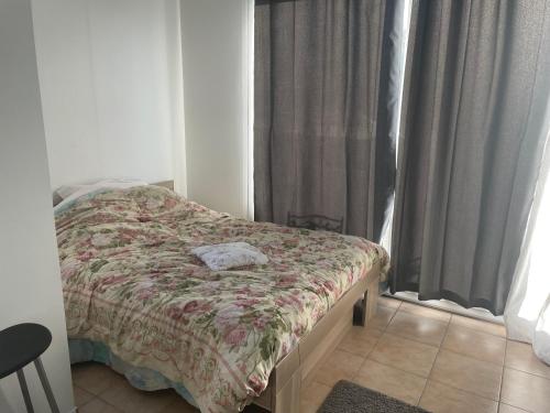 une chambre avec un lit et une fenêtre avec des rideaux dans l'établissement Maison T 2 meublé confort proche aéroport, à Pusignan