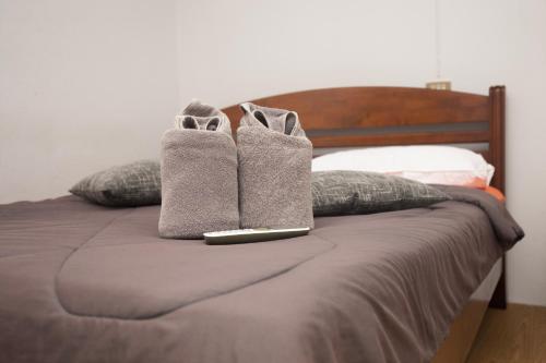 a pair of socks and a laptop on a bed at Holiday Phangan - Hostel & Bar in Thong Sala