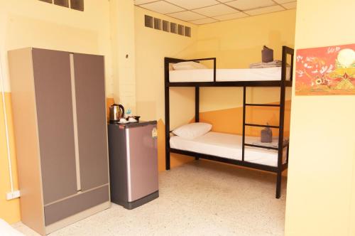 a room with two bunk beds and a refrigerator at Holiday Phangan - Hostel & Bar in Thong Sala