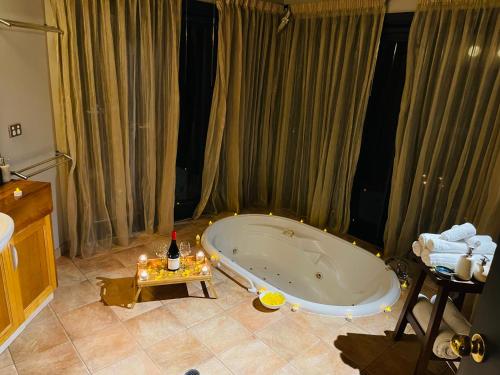 a bathroom with a bath tub with candles on a table at Woodlands rainforest retreat in Narbethong