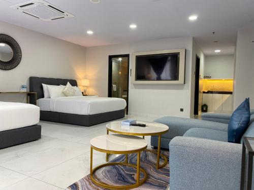 sala de estar con 2 camas y sofá en Serviced Apartments @ Times Square Kuala Lumpur, en Kuala Lumpur