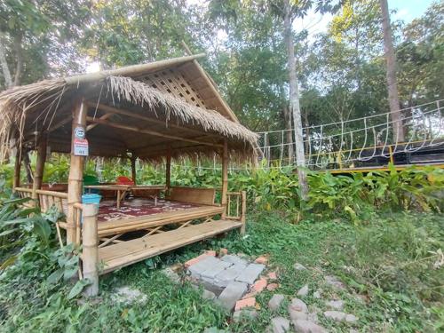 a hut with a table and a straw roof at Bouasavan Hotel and Garden in Savannakhet