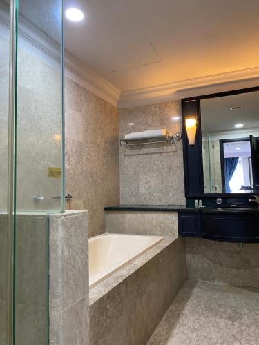 a bathroom with a bath tub and a mirror at Serviced Apartments @ Times Square Kuala Lumpur in Kuala Lumpur