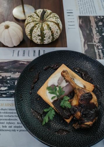 a black plate of food on a table with pumpkins at Hotel Dębowy Biowellness & SPA Góry Sowie in Bielawa