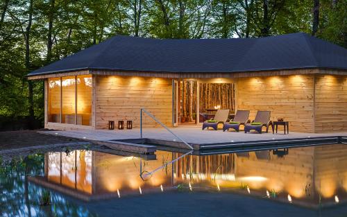 ein Blockhaus mit einem Pool davor in der Unterkunft Hotel Dębowy Biowellness & SPA Góry Sowie in Bielawa