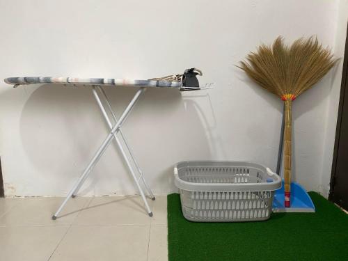 a shelf on a wall with a broom and a basket at Cik Misi Homestay Jeniang in Sik
