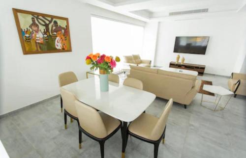 sala de estar con mesa, sillas y sofá en Luxurious King Suite Two Bedroom Space Available, en Accra