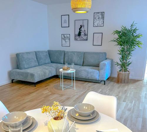 ein Wohnzimmer mit einem blauen Sofa und einem Tisch in der Unterkunft Suites in Mödling in Mödling