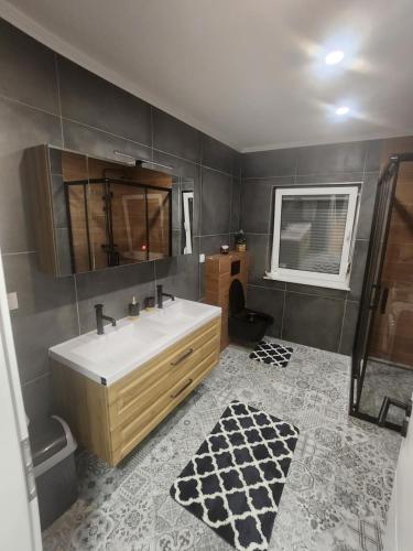 ein Badezimmer mit einem weißen Waschbecken und einem Spiegel in der Unterkunft Šimun i Roko in Ozalj