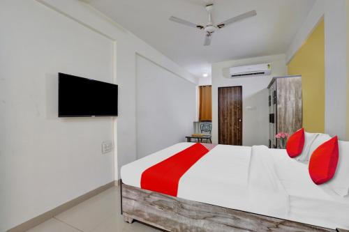 a bedroom with a bed and a flat screen tv at Hotel Relax Inn in Gandhinagar