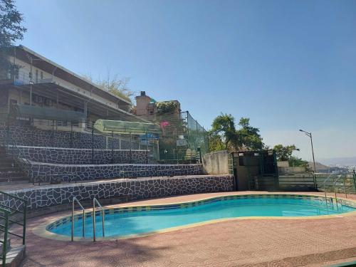 an empty swimming pool in an empty stadium at Hotel O Pratikruti Resort in Pune