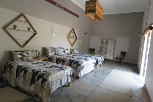 1 dormitorio con 2 camas y ventana en Faith City Guesthouse en Outjo