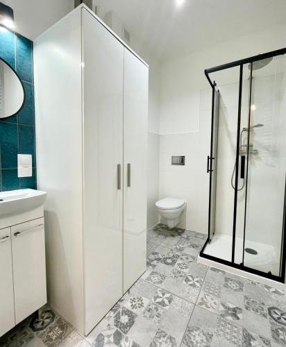 a white bathroom with a shower and a toilet at Studio Bielawa u podnóża Gór Sowich in Bielawa