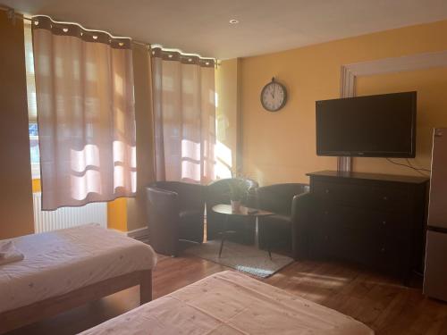 a living room with a flat screen tv and a table at Gästezimmer an der Stadtmauer in Besigheim