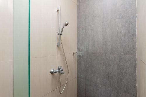 a shower with a shower head in a bathroom at RedDoorz Plus near Kelapa Dua Kebon Jeruk in Jakarta