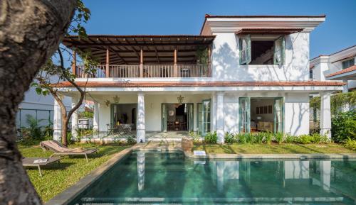 a house with a swimming pool in front of it at La Mosteiro in Assagao, Splendid 3&4BHk Villas with Private Pool, Private Parking, Garden, Caretaker, Kitchen & Security in Vagator