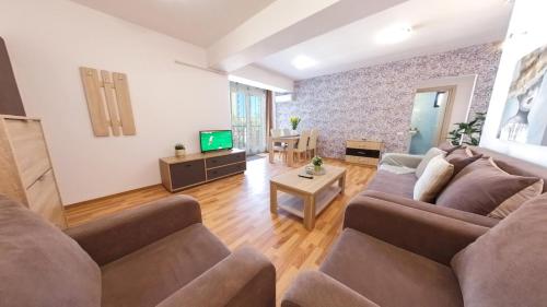 a living room with two couches and a tv at Old Town Flowery Apartment in Bucharest