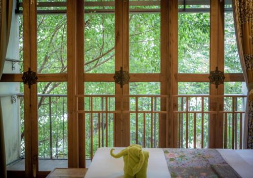 a room with a large window with a bed in front at Phranakorn-Nornlen in Bangkok