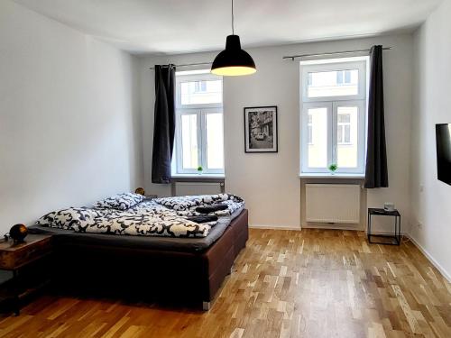 1 dormitorio con 1 cama y 2 ventanas en Sunny apartment with 1 balcony, en Viena