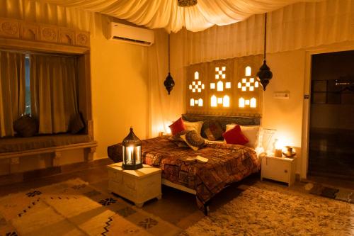 een slaapkamer met een bed en een raam en verlichting bij Casa De Kaku Jaisalmer in Jaisalmer