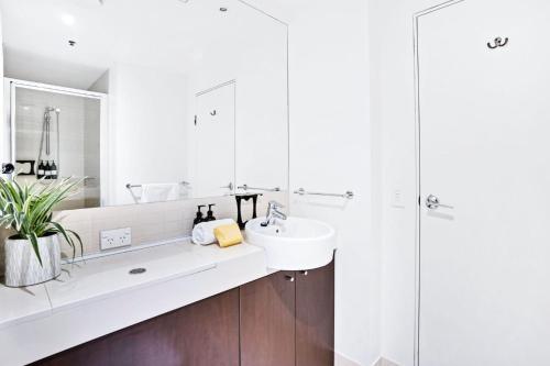 a white bathroom with a sink and a shower at 219 Harbour Lights with Ocean Views in Cairns