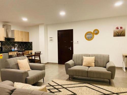 ein Wohnzimmer mit 2 Sofas und einer Küche in der Unterkunft Executive 2 bedroom Apartment At East Legon in Accra