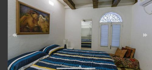 1 dormitorio con 1 cama y una pintura en la pared en Luxury Large Apartment With Colonial Balcony, en Cartagena de Indias