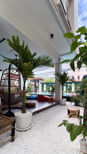 a living room with potted plants in a building at THE PLACE Hostel Siem Reap Angkor in Siem Reap